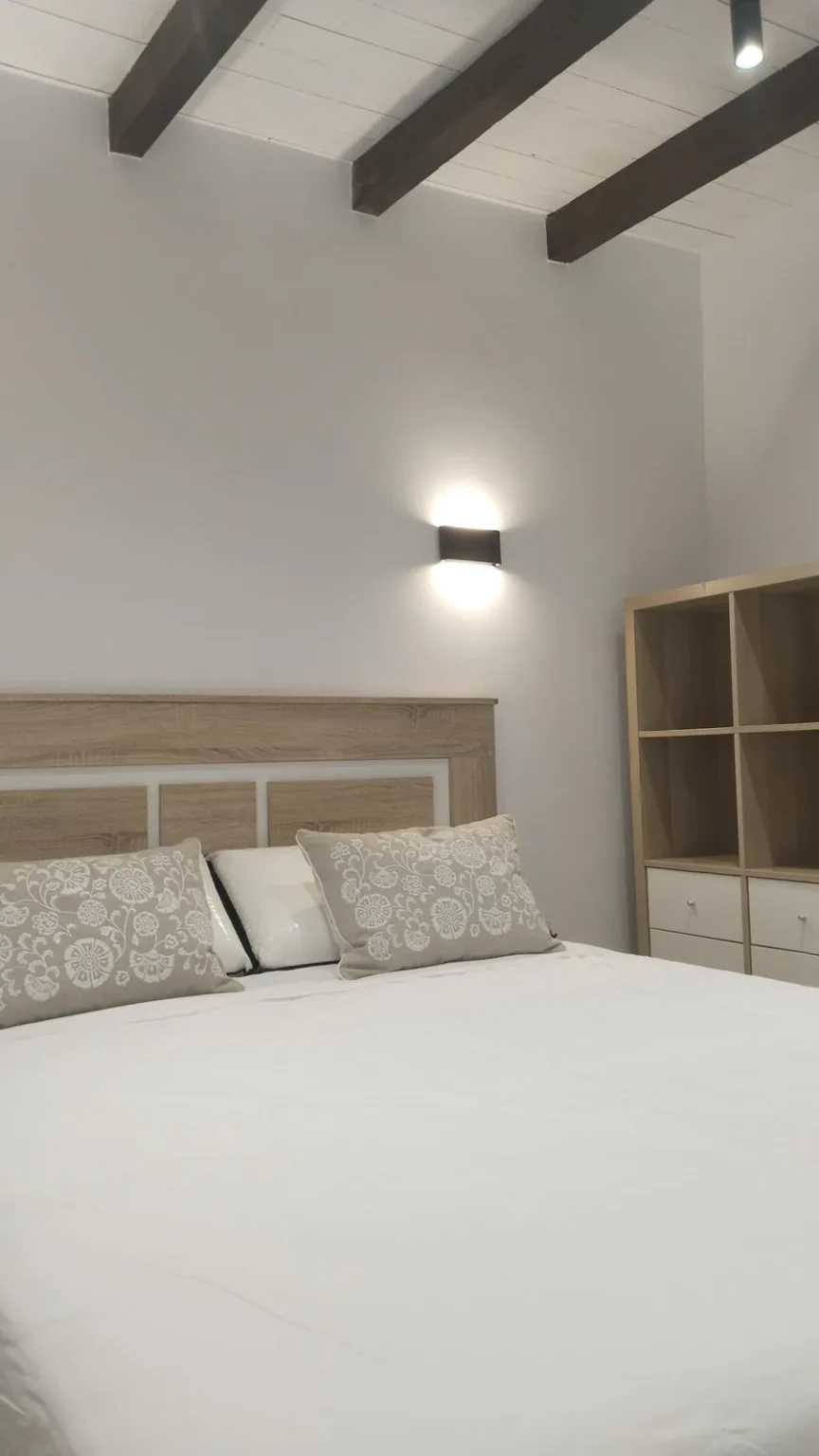 Habitación con cabecero de madera y estantería